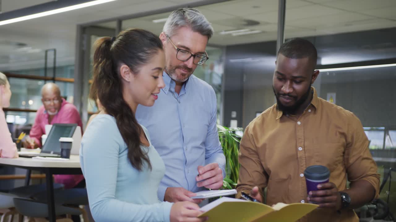 diversos colegas de negocios masculinos y femeninos hablando y sosteniendo documentos