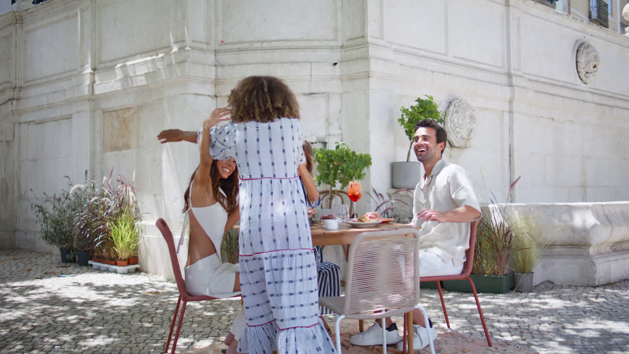 도시 카페에서 함께 모인 행복한 그룹. 행복한 친구들이 여자에게 인사를합니다.