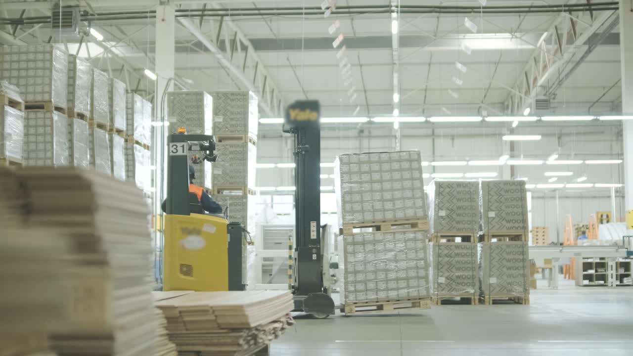 Un carrello elevatore che sposta i pallet di merci in un grande magazzino