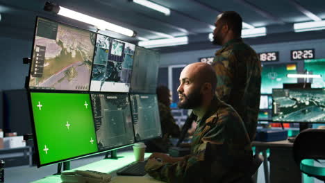 Army-soldier-looking-at-chroma-key-screens-in-command-center