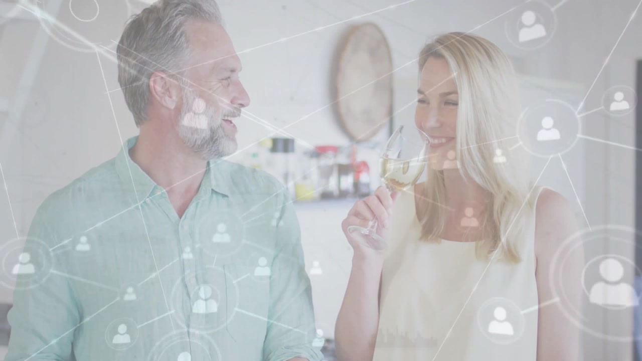 Uomo che taglia verdure e donna che sorseggia vino in cucina, mentre una sovrapposizione di rete tecnologica si espande, stimolata dalla conversazione.