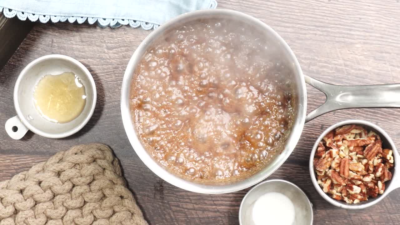 Baking delicious caramel pecan brownies. Using a spatula for stirring boiling caramel for a topping. Freshly baked gooey chocolate brownies with sweet caramel and nutty pecans.