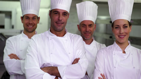 four happy chefs looking at camera with arms crossed