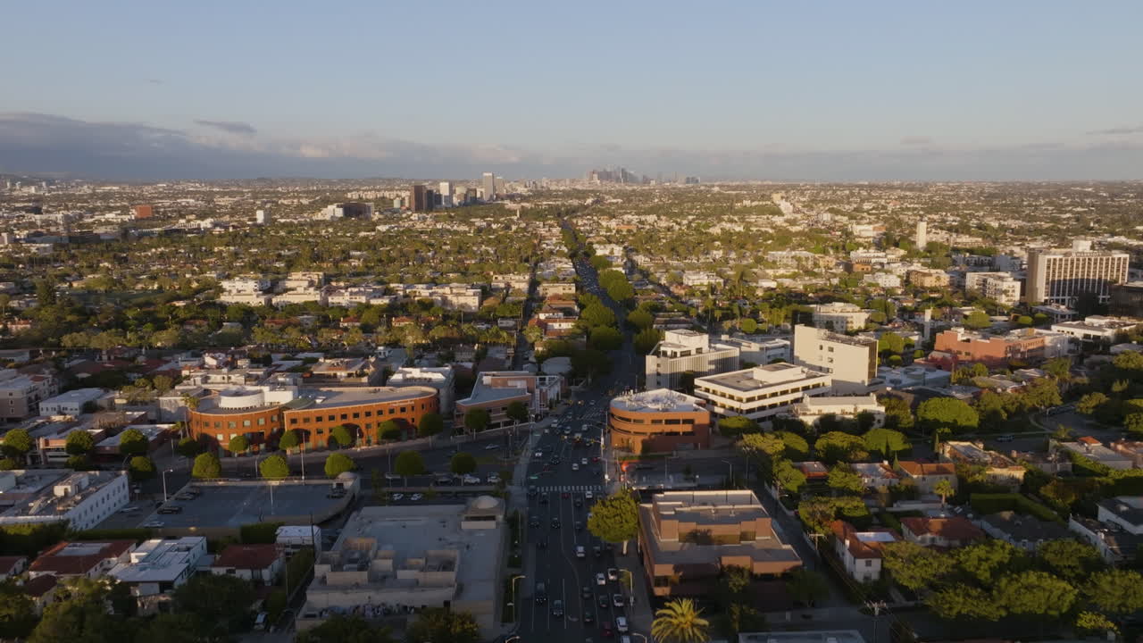 Vista aerea che segue il traffico sulla W Olympic Blvd, nelle soleggiate Beverly Hills, Los Angeles - in direzione opposta.