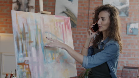artist talking on phone in art studio