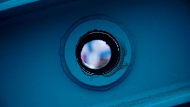 Close-up of a blue metal component with a circular hole