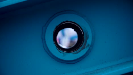 close-up of a blue metal component with a circular hole