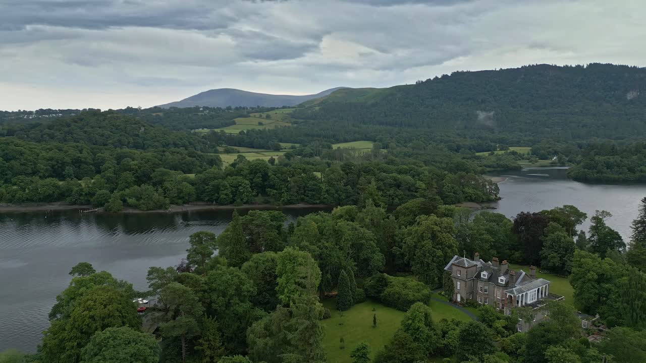 더웬트워터, 케스윅, 강 보트가 있는 잔잔한 호수, 폭풍우가 치는 하늘에 있는 더웬트 섬의 공중 비디오 영상