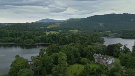 aerial video footage of derwent island on derwentwater, keswick, a calm lake with river boats and a stormy sky