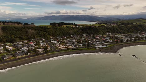 coastal town of kaikoura, dark sand beach, residential houses, south island, new zealand. aerial