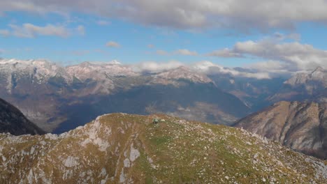 Aerial-circular-pan-of-mountain-peak-with-three-people-on-top