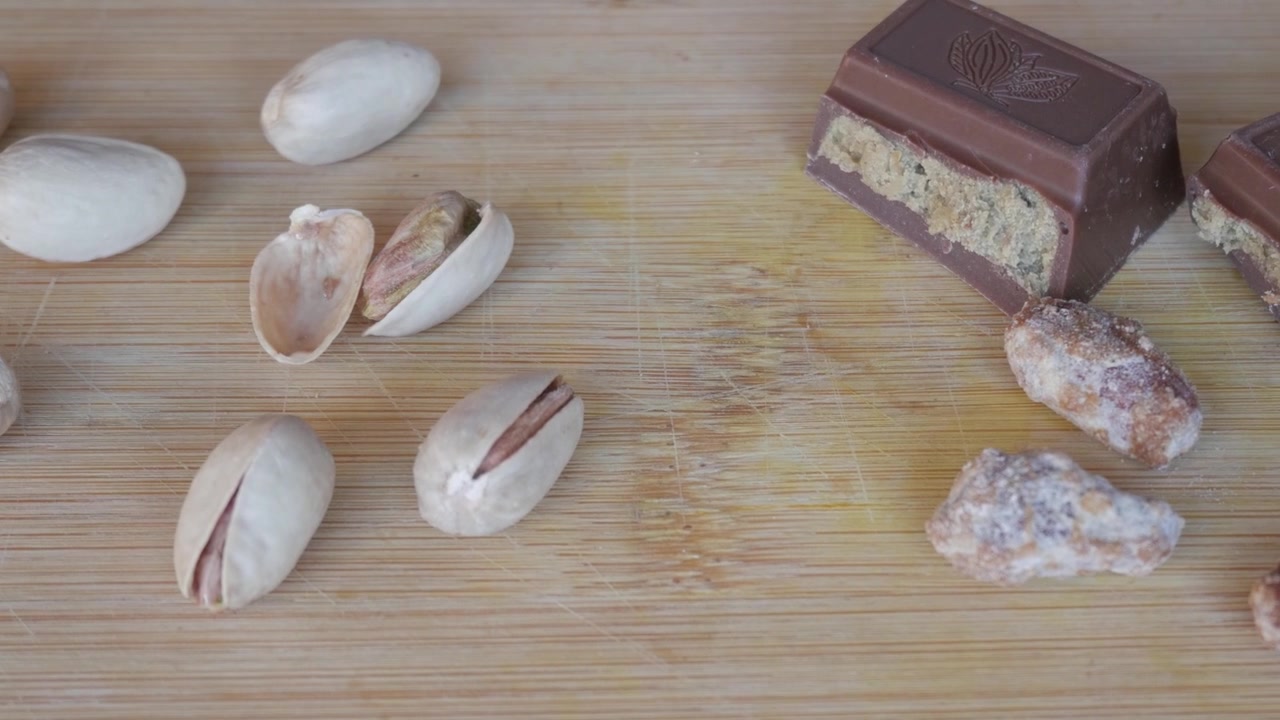 Pistachios and Dubai chocolate on wooden board, inviting and delicious