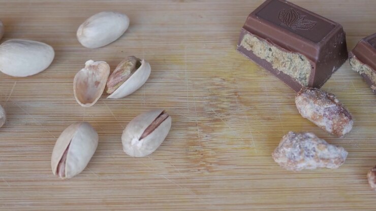 Pistachios and Dubai chocolate on wooden board, inviting and delicious