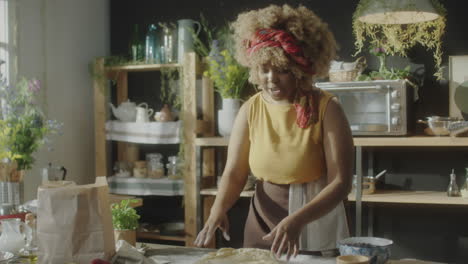 woman kneading dough in a rustic kitchen