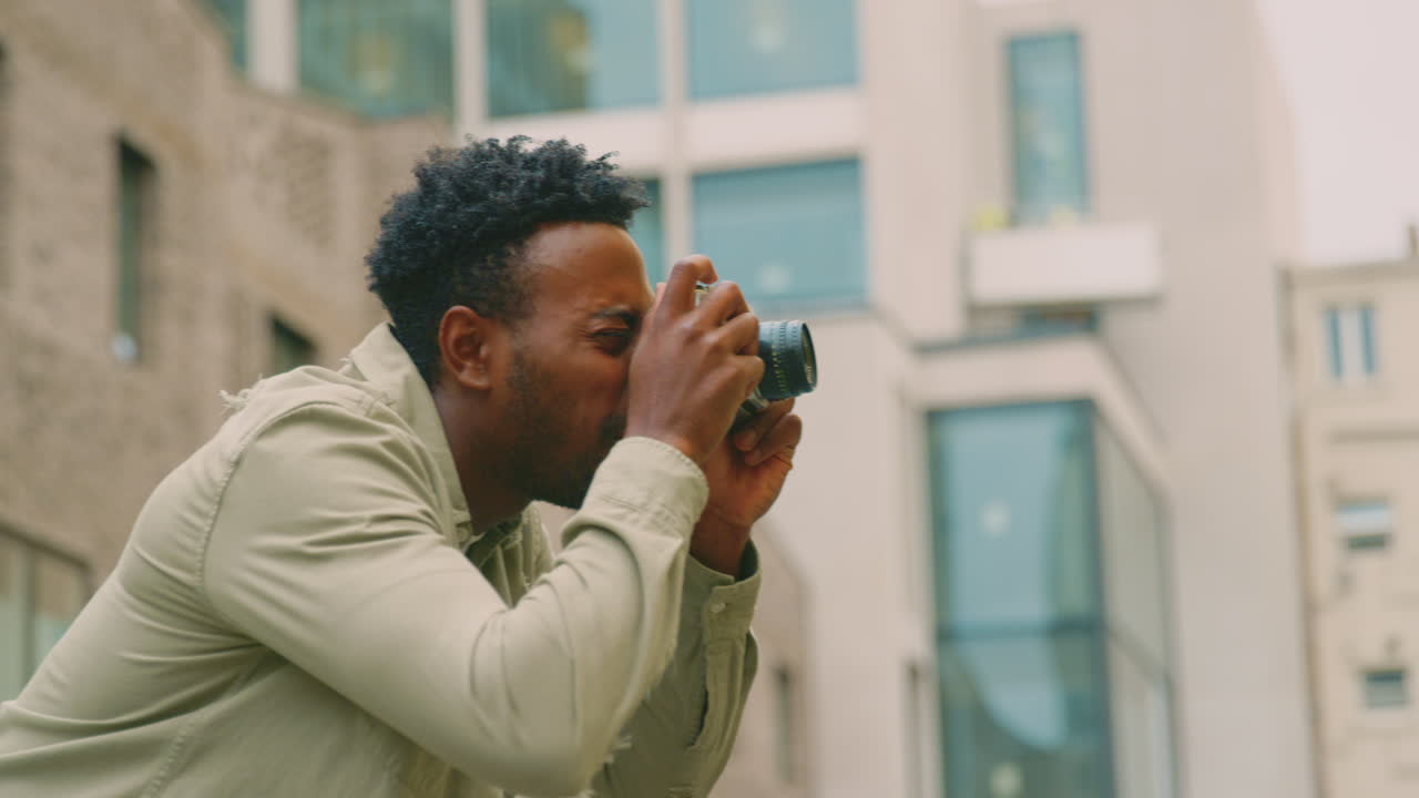 Young Man In City Taking Photo On Digital Camera To Post To Social Media