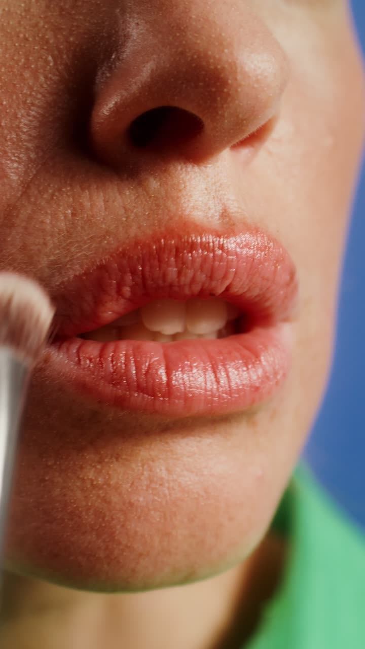 Close-up of a woman applying makeup to her lips