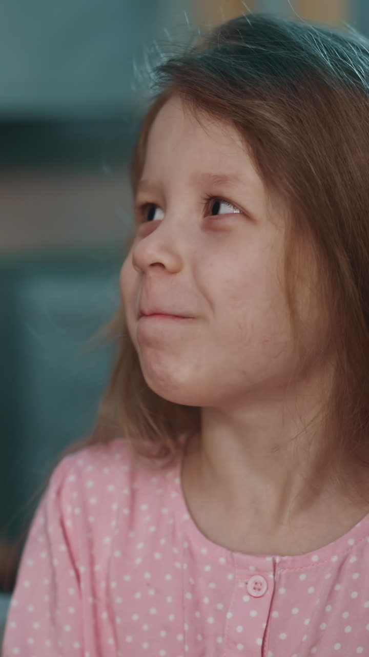 madre sonriente pone píldora en la lengua de la pequeña hija divertida para curar la enfermedad en fondo borroso en una habitación semi-oscura en casa vista de cerca en cámara lenta