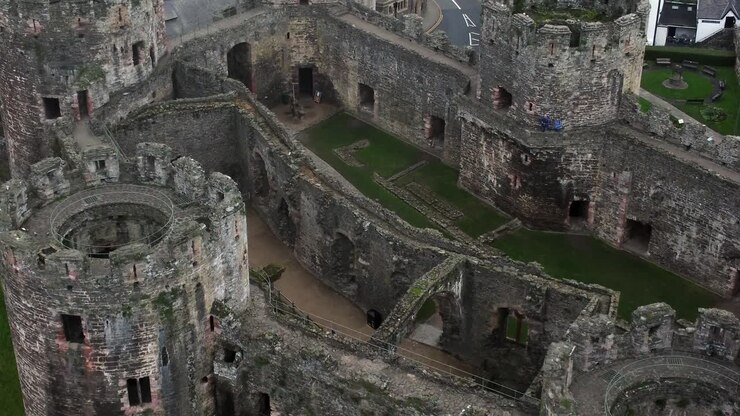 Castello storico di Conwy, veduta aerea della città simbolo, rovine, mura in pietra, merlature, attrazione turistica, sorvolo a volo d'uccello, primo piano, inclinazione verso l'alto