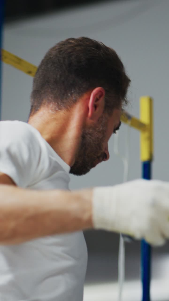 Concentrazione e abilità: una persona concentrata impegnata in un lavoro di precisione mentre utilizza un rullo di vernice su un'impalcatura, a dimostrazione di professionalità e maestria artigianale