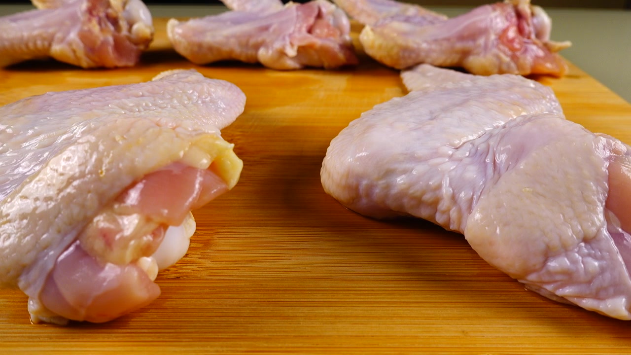 Ali di pollo fresche su un tagliere