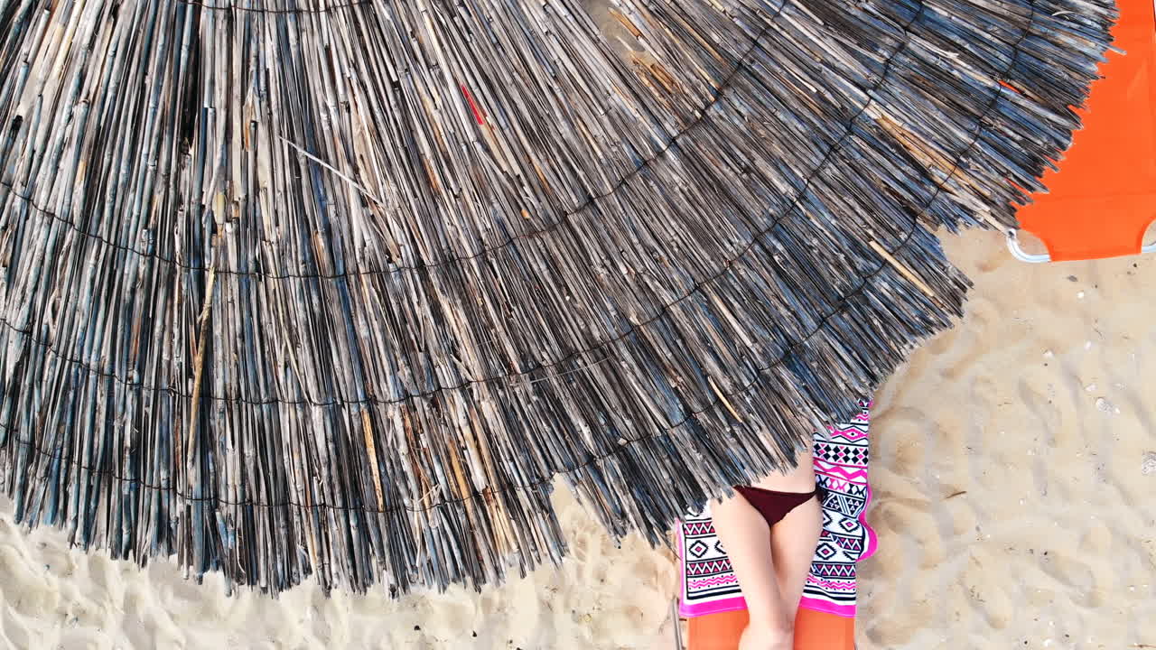 Top view of a woman laying on sunbed, relaxing and looking up