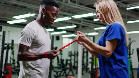 physical therapist assisting patient with exercise band