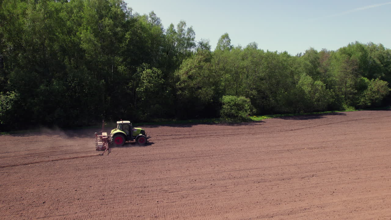 Tractor ploughing field in summer, Latvia