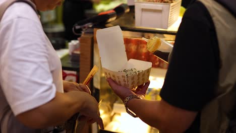 people sharing pan-fried buns at food stall