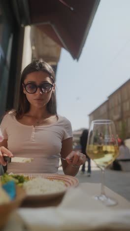 Young woman eating lunch outdoors at a cafe