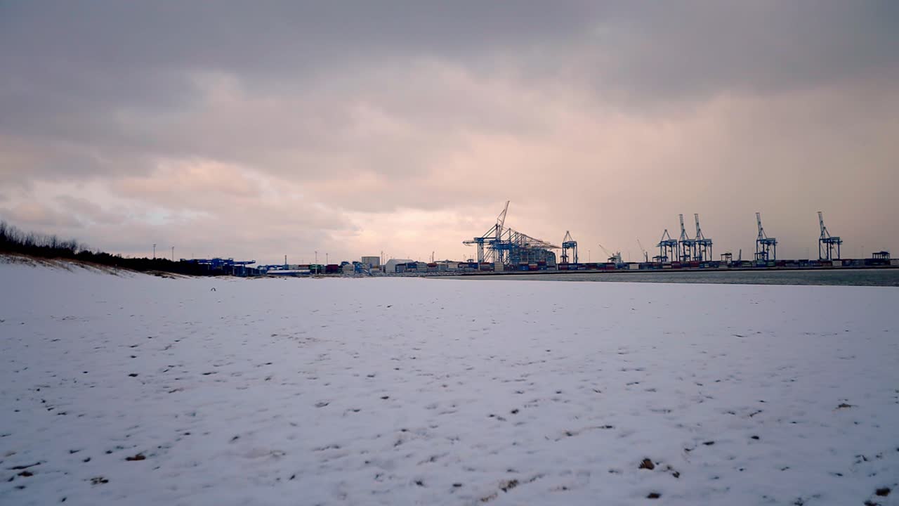 많은 사람들이 해변과 건설 현장에 서 있는 눈으로 뒤덮인 해변