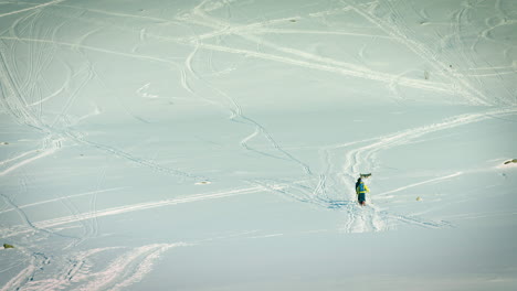 toma de lente larga de tres personas y su perro caminando por la nieve