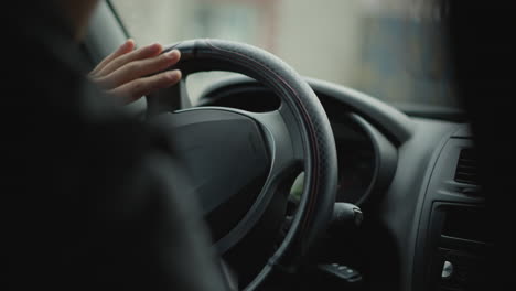 back view of car buff driving, skillfully turning steering wheel to execute smooth turn, blurred street scene visible through window, capturing driver focus, control and urban commute vibe