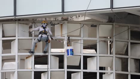 worker cleaning windows on a high-rise building.