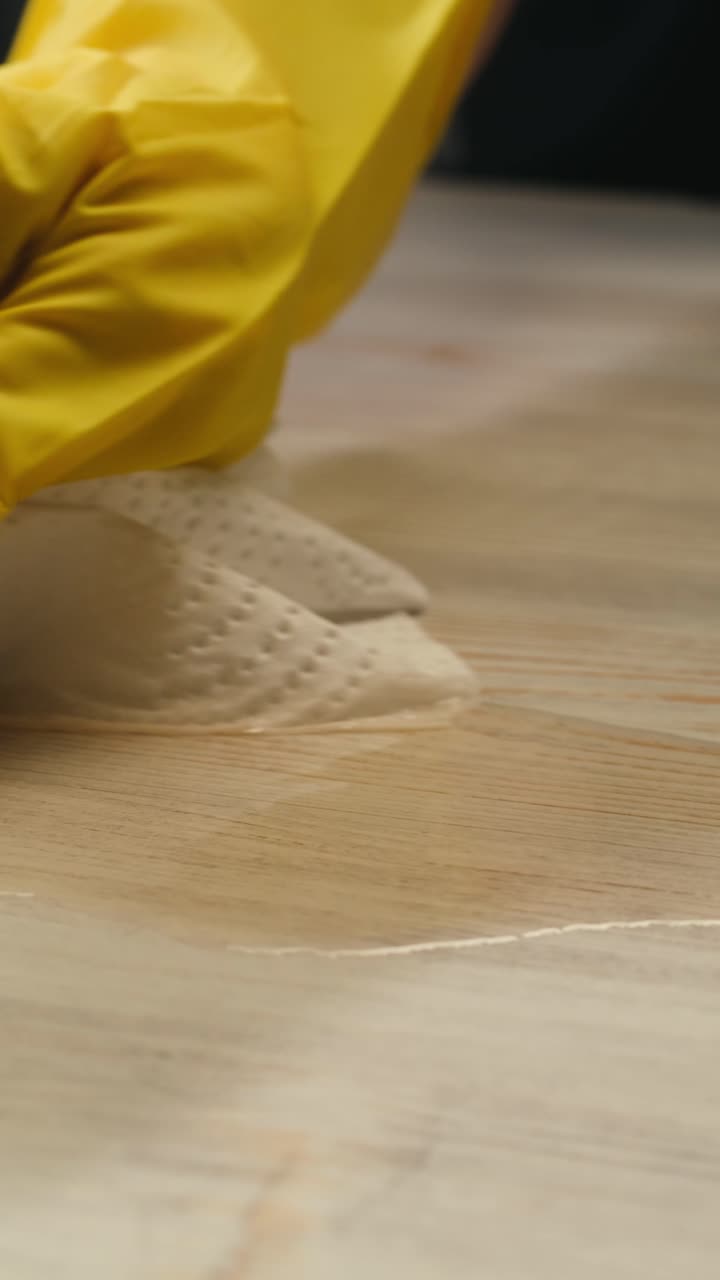 Hand in Yellow Glove Wiping Spill with Paper Towel
