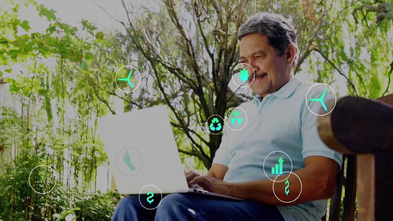 Uomo anziano che digita al laptop in giardino, attivando icone verdi che visualizzano energia e finanza intorno a lui.