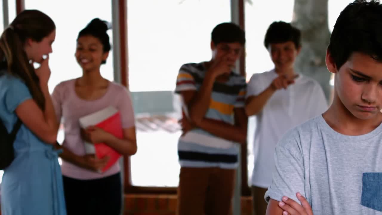 학교 친구 들 이 복도 에서 슬픈 소년 을 괴롭히고 있다