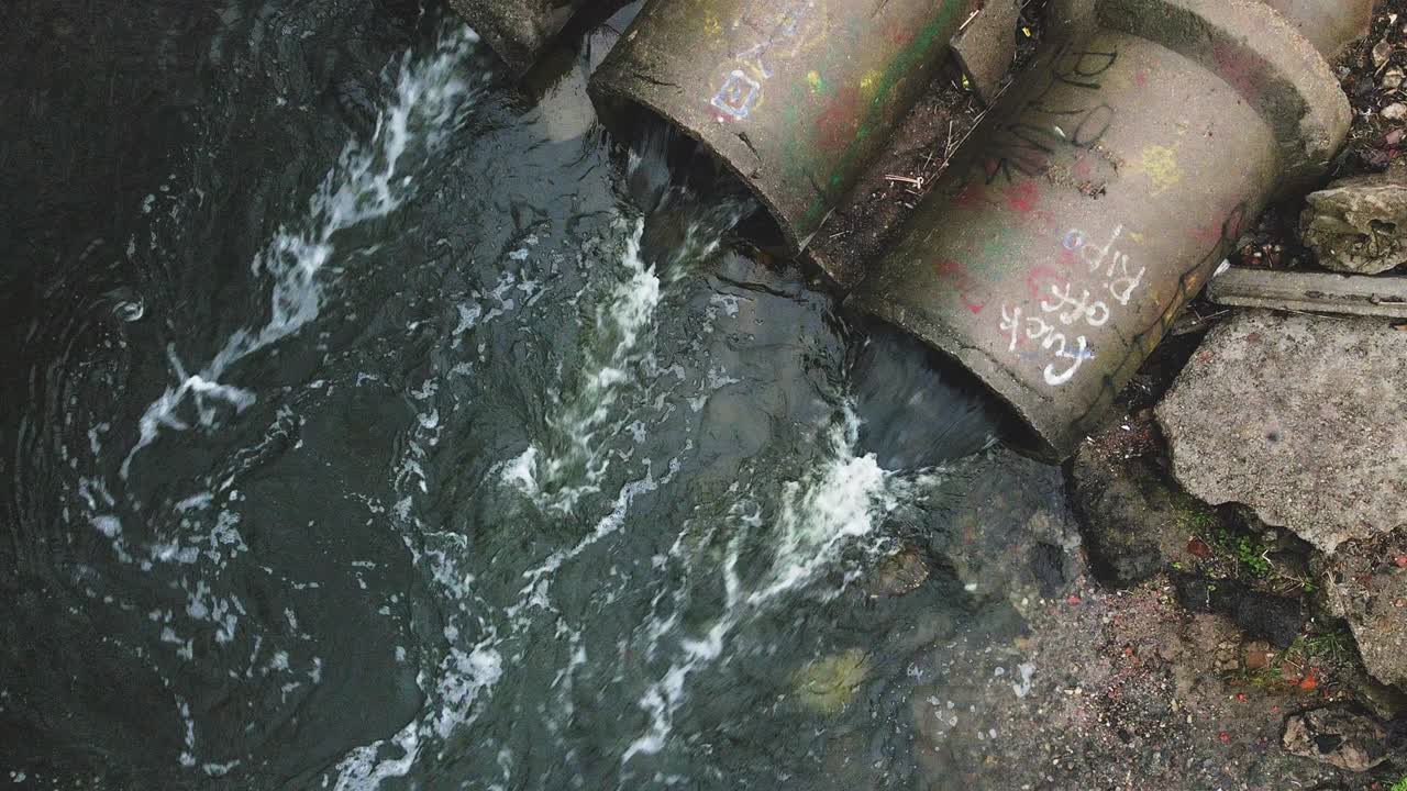 콘크리트 하수구에서 흐르는 물줄기, 공원의 오염된 물체, 카메라를 내려놓은 드론에서 촬영