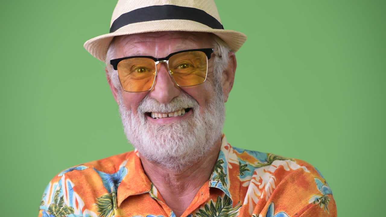 hombre turista barbudo y guapo listo para las vacaciones contra un fondo verde