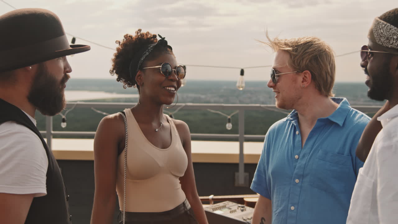 Happy Friends Chatting during Party on Rooftop