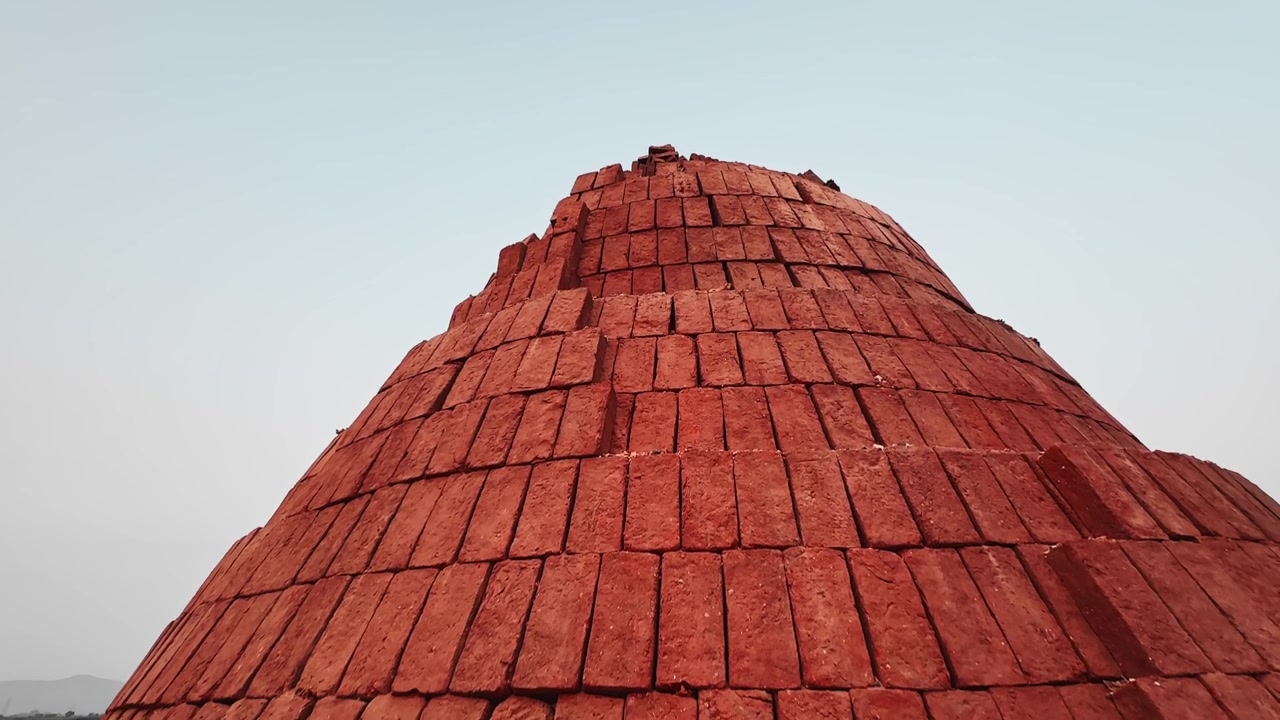 Jib up shot of a pile of mud bricks ready for use at the brick making facility
