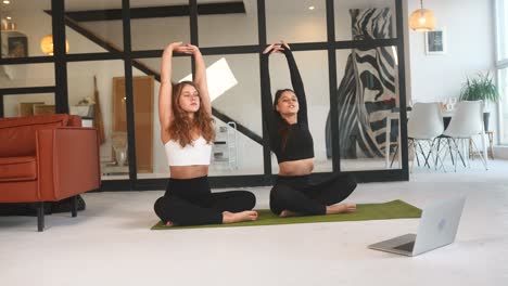 dos mujeres haciendo yoga en casa