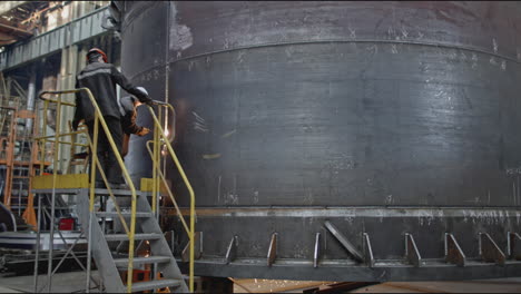 welding a large metal tank in a factory