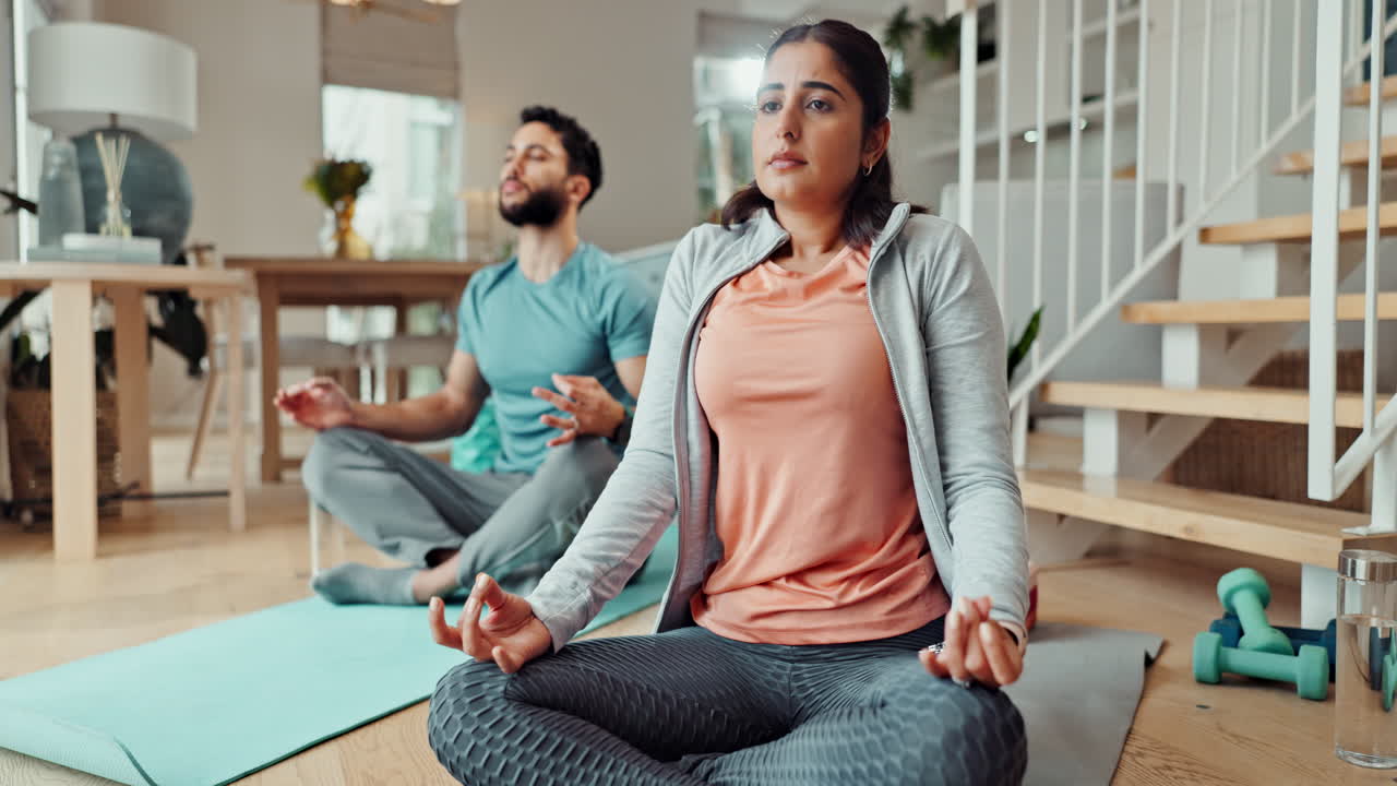pareja practicando yoga y meditación en casa