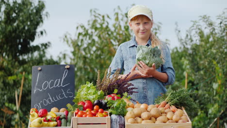 Porträt-Des-Bauernkindes-Mit-Kohl-In-Den-Händen-Hinter-Der-Bauernmarkttheke