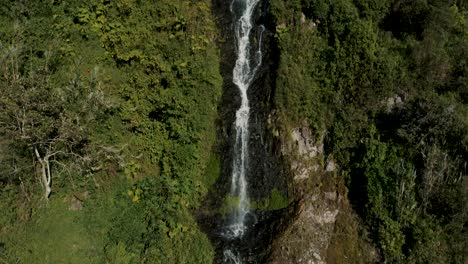 Tilt-Down-Through-Virgin-Waterfalls-Flowing-From-Lush-Valley-In-Baños-de-Agua-Santa-City,-Ecuador