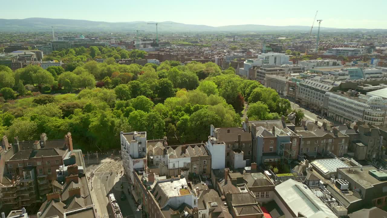 Forward travelling aerial video of St Stephen's Green and the surrounding area in Dublin City Centre, County Leinster, Ireland on a bright sunny day. Filmed in 4K, 60FPS and with Rec709 color.