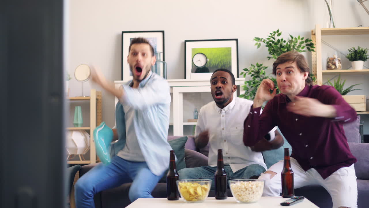 amigos viendo un partido de fútbol en casa