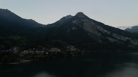 Clip-Aéreo-Del-Lago-En-El-Valle-Alrededor-De-Los-Picos-De-Las-Altas-Montañas-Con-Una-Fuente-Y-Muchos-Deportes-Acuáticos