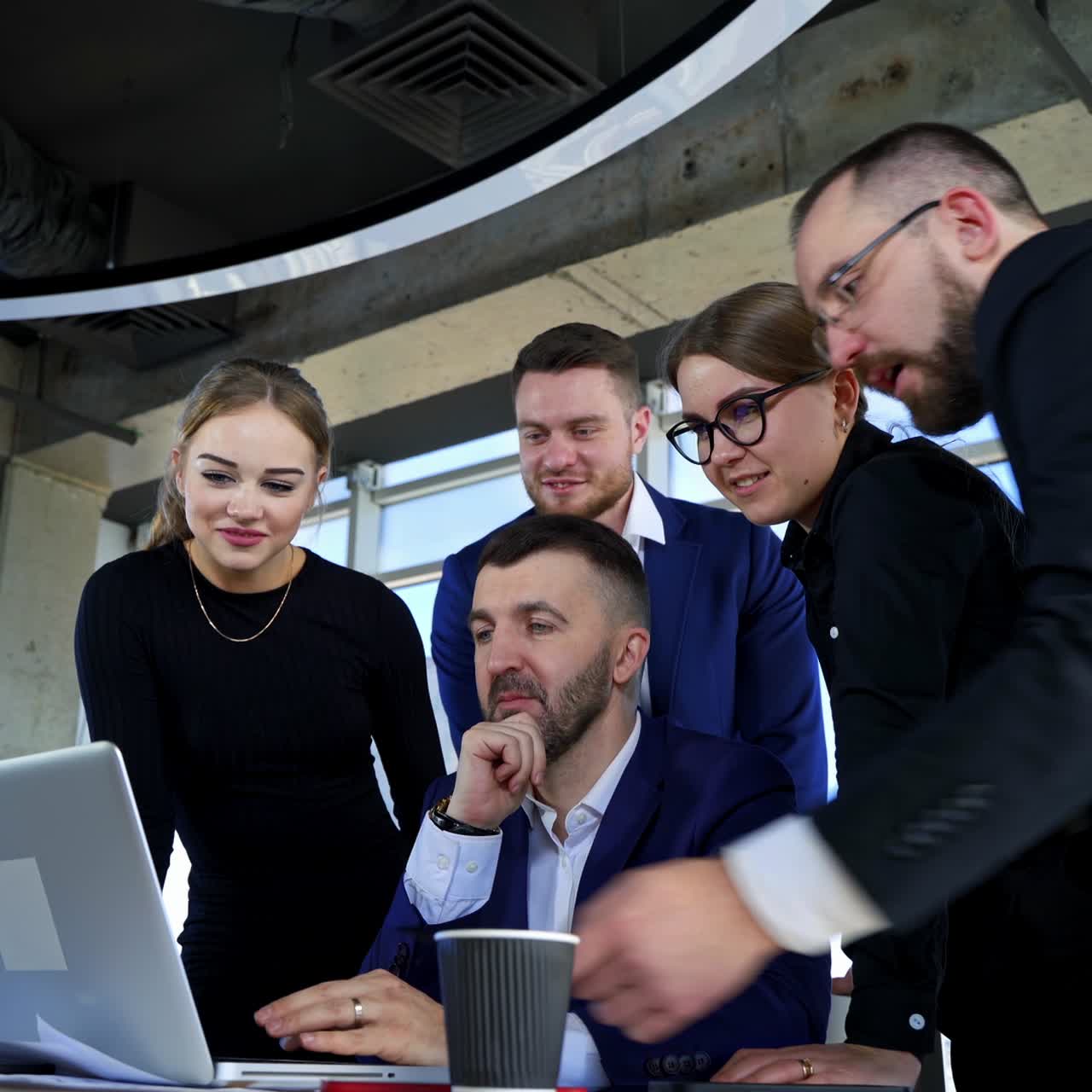 Team of entrepreneurs working together. Group of business partners work on a laptop and discuss new project in office room