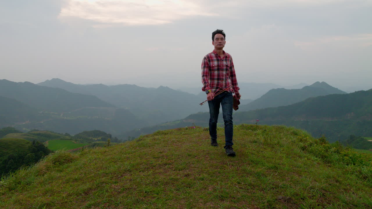 아시아 남자가 노래를 연주하고 돌아오고 있습니다.